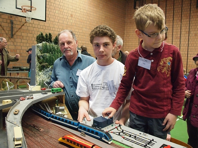 Faszination Modelleisenbahn: Vereinspräsident Marcel Häring (l.) und Gabriel Eckl (Mitte) zeigen Gästen ihre Anlage.  Foto: Tobias Gfeller