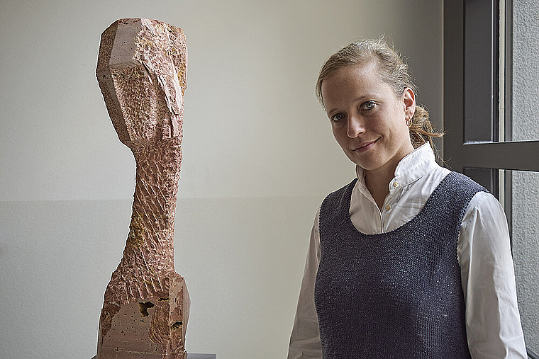 Kopf geneigt: Barbara Schnetzler mit einer ihrer Skulpturen ohne Titel, in persischem Travertin, von 2016.  Foto: Bea Asper