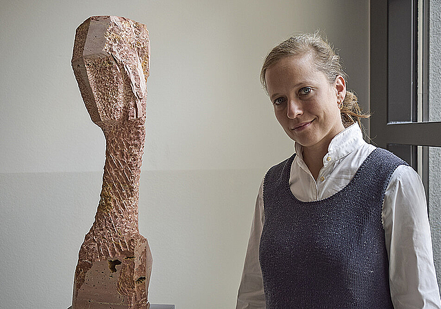 Kopf geneigt: Barbara Schnetzler mit einer ihrer Skulpturen ohne Titel, in persischem Travertin, von 2016.  Foto: Bea Asper