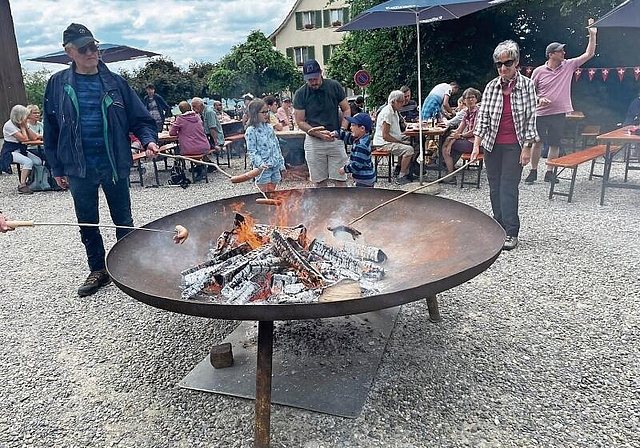 Generationenübergreifender Austausch: An der offenen Feuerstelle konnten die Teilnehmerinnen und Teilnehmer ihre ­traditionelle Schweizer Wurst bräteln. Foto: Bea Asper