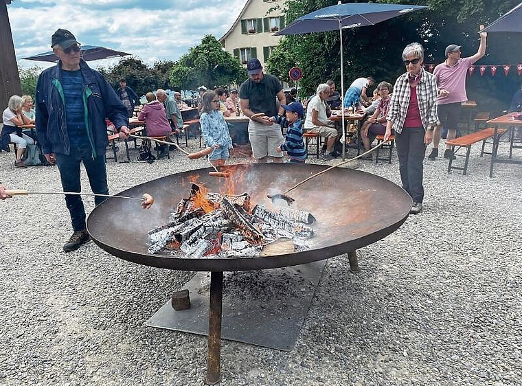 Generationenübergreifender Austausch: An der offenen Feuerstelle konnten die Teilnehmerinnen und Teilnehmer ihre ­traditionelle Schweizer Wurst bräteln. Foto: Bea Asper