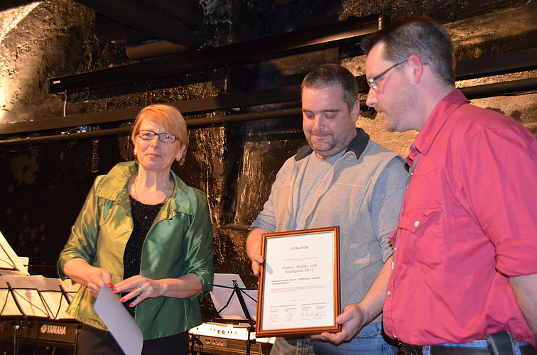 Verkehrsverein geehrt: Marianne Hollinger überreicht im Schloss-Chäller die Urkunde an Rolf Imgrüth (Präsident, Bildmitte) und Mark Schaub («Anführer» der Bänkli-Gruppe).