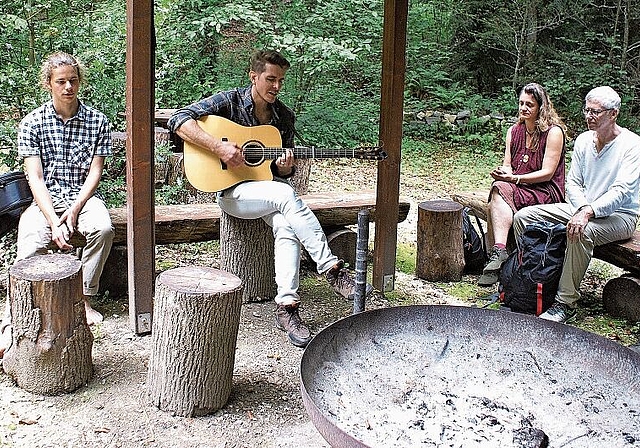 Wanderkonzert mit einzigartigen Stationen: Flavian Graber (2. v. l.) mit den Teilnehmerinnen und Teilnehmern des Wanderkonzerts an der Feuerstelle. Foto: Jürg Jeanloz