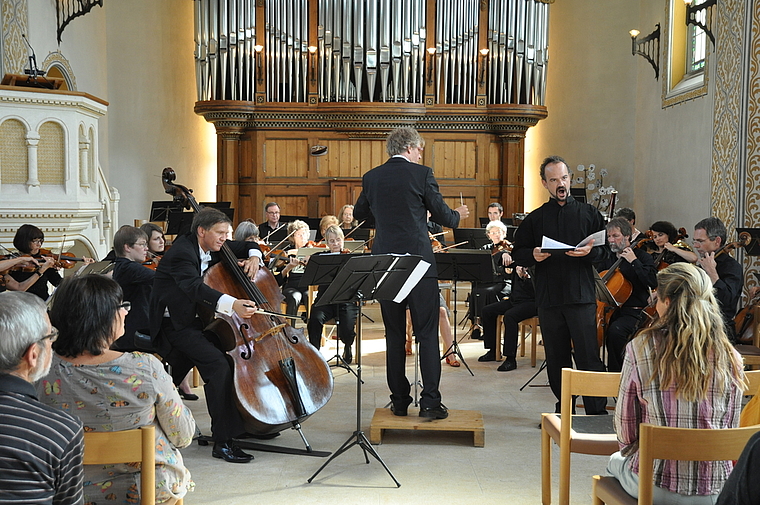 Ausdrucksstark: Das von Markus Teutschbein dirigierte Orchester Arlesheim mit Vitalij Kravtchenko am Kontrabass und dem Vokalsolisten Robert Koller.  Foto: Isabelle Hitz