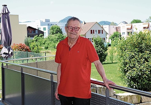 Mit Sicht auf seinen ehemaligen Arbeitsort: Urs Spielmann, ehemaliger Heimleiter auf der Terrasse seiner Wohnung in Breitenbach, im Hintergrund das AZB. Foto: Gaby Walther