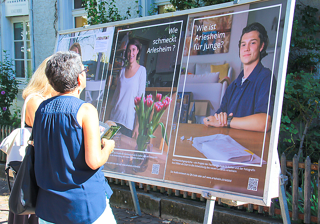 Küchentischgespräche: Mit dem Handy kann man den QR-Code auf den Plakaten im Dorfkern scannen ,um den acht befragten  Arlesheimerinnen und Arlesheimern zuzuhören. Foto: Tobias Gfeller 