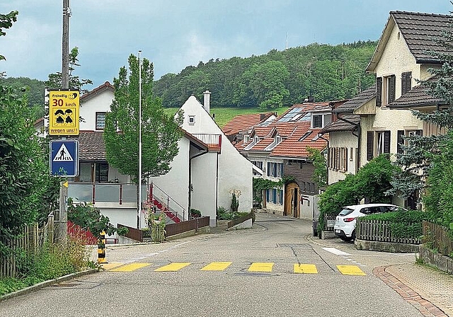 Die Nerven liegen blank: «Freiwillig 30 km/h – wegen uns!» ist auf dem gelben Schild am Ortseingang zu lesen. Foto: Bea Asper