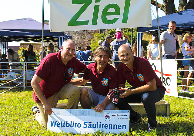 Hatten ein saumässiges Vergnügen: Statthalter Roger Burri, Zeremonienmeister René Piesker und Säckelmeister Andreas Siegfried vor dem Zieltrog des Säulirennens.  Foto: Axel Mannigel