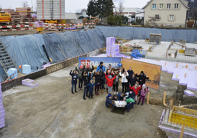 In der Baugrube: «Fokus»-Schulkinder platzieren eine mit persönlichen Gegenständen gefüllte Holzkiste in die Bodenöffnung.  Foto: Thomas Kramer