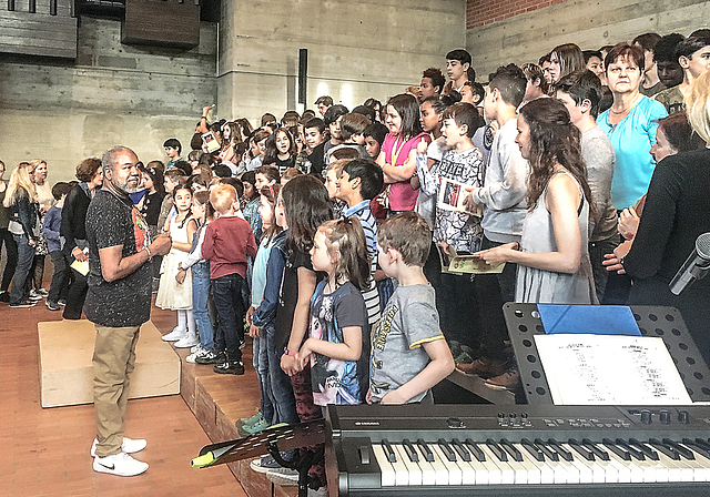 Vor dem Auftritt: Gospelsänger Michael Crews stimmt die Kinder mit einem kleinen Einsingen für das Konzert im Mischeli ein.  Foto: Caspar Reimer