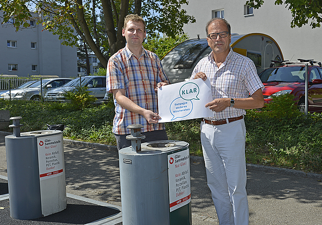 Kampagnestart: Münchensteins Gemeindepräsident Giorgio Lüthi (l.) und Projektleiter Florian Inneman präsentieren das «KLAR»-Logo vor der Unterflur- Wertstoffsammelstelle Lärchenstrasse-Grubenstrasse.  Foto: ZVG