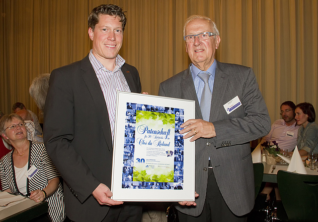 Abschiedsgeschenk: Michael Dreier, frischgebackener Präsident des Vereins Gewerbe und Industrie Aesch, übergibt dem frischgebackenen Ehrenpräsidenten Roland Hohl eine Rebpatenschaft mit dem passenden Namen «Clos du Roland».  Foto: ZVG/Claudia Sc