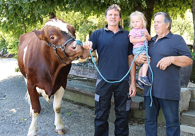 <em>Die Kleine hilft schon mit: </em>Vater Urs (l.) und Grossvater Sepp Wiggli mit Enkelin Tyara und dem Stier Zauber, Hauptpreis am 100. Basler Schwingfest im vergangenen Mai, den sich Nick Alpiger erschwungen hat.<em>Foto: Benildis Bentolila</em>