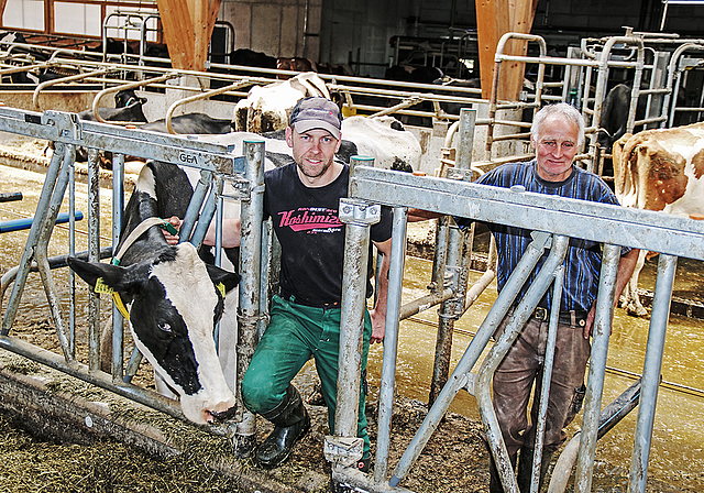 Die beiden Bauern der Betriebsgemeinschaft Langackerhof: Thomas Vögtli (r.) und Seppi Vögtli mit Kuh Lindsey.  Foto: Benildis Bentolila.