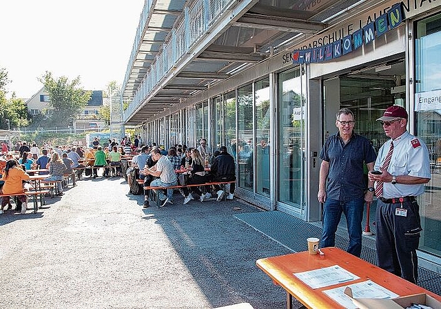 Tag der offenen Tür: Schulleiter Gaston Caviezel (2.v.r) freut sich über die vielen Besuchenden, der uniformierte Vertreter der DARU-Wache kontrolliert die Covid-Zertifikate, ohne die es keinen Einlass gab. Foto: Martin Staub