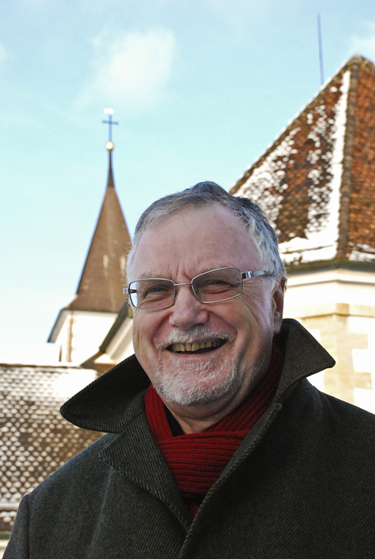 Von einem, der auszog, die Menschen zu lieben: Pfarrer Bernhard Schibli vor der Kirche Aesch.  Foto: Thomas Brunnschweiler