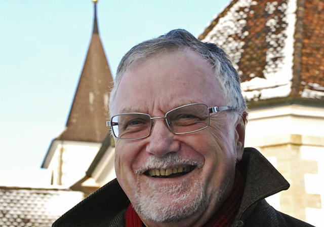 Von einem, der auszog, die Menschen zu lieben: Pfarrer Bernhard Schibli vor der Kirche Aesch.  Foto: Thomas Brunnschweiler