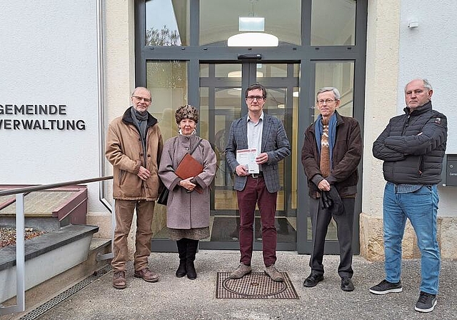 Unterschriften aus der ganzen Welt: Therese Anner (2. v. l.) und weitere Petitionäre übergeben die Petition an Gemeindepräsident Daniel Urech (in der Mitte). Foto: Jeannette Weingartner