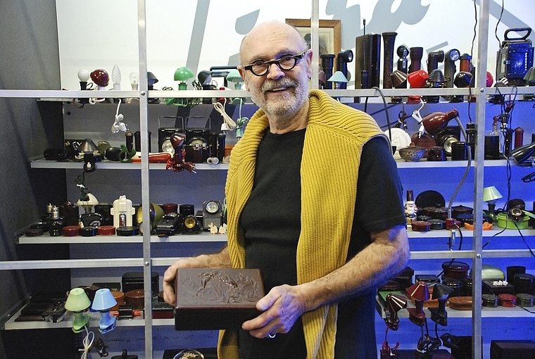 Bakelit wird museal: Jürg Josef Zimmermann präsentiert eine Bakelitdose mit kunstvollem Relief. Im Hintergrund: Vitrine mit Bakelit-Lampen.  Foto: Thomas Brunnschweiler