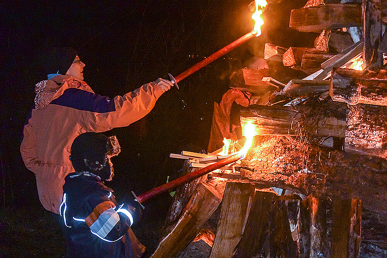 Der Feuerstoss wird in Brand gesetzt: Kinder und Erwachsene trotzten der Kälte und brachten am Sonntag Licht ins Dunkel.