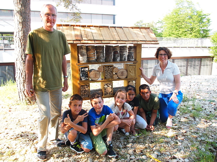 Haben ein «Hotel» für Wildbienen gebaut: Peter Hügin, Nathalie Meyer und Schüler von der Primarschule Aesch.  Foto: Tobias Gfeller