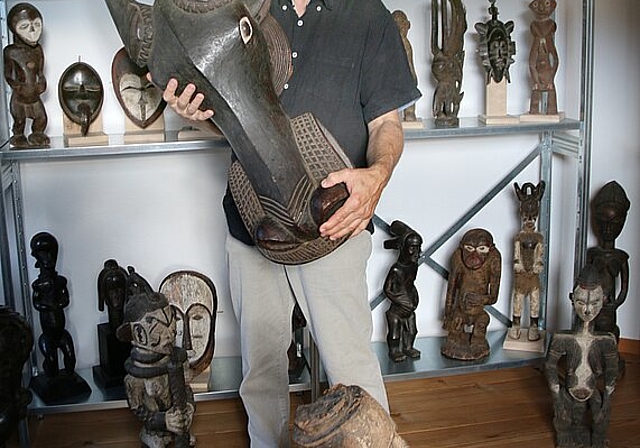 Afrikanische Kunst: Jean-Marc Pache hält eine grosse Tiermaske, die für rituelle Tänze gebraucht wurde, in den Händen. Foto: Gaby Walther