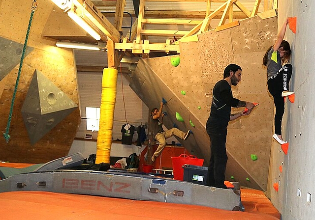 <em>Bis am Sonntag ist der Aufbau der Boulderanlage fertig: </em>Raphael Metzger (hinten) und Alessandro Esposito montieren die Griffe, Valentina testet die Abstände.Foto: Gaby Walther