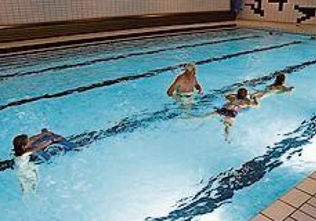 Übung beim Kikkerschwimmen: Georges Götte und drei Kinder mit speziellem Schwimmbrett. Foto: Carlo Lang