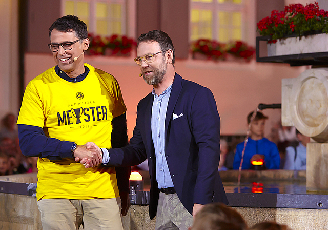 Von Nik Hartmann zum YB-Fan verdonnert: Gemeinderat Lukas Stückelberger trägt das gelbe Meistershirt mit Fassung.  Fotos: SRF und Tobias Gfeller
