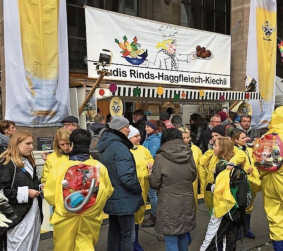 «Die Wurst ist uns wurst»: Der Stand von Trudis Rinds-Haggfleisch-Kiechli an der Basler Fasnacht passt genau zwischen die zwei Säulen vor der ehemaligen Hauptpost. Foto: zVg
