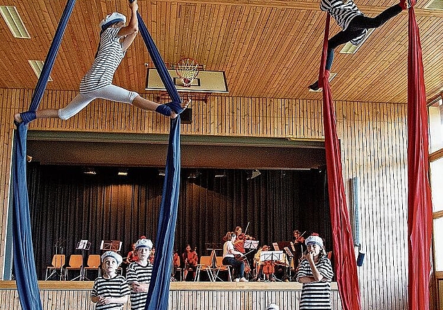 Akrobatik mit Musik: Die Turnenden der Zirkusgruppe FederBlau mit der Schiffskapelle der Musikschule im Hintergrund. Foto: Martin Staub