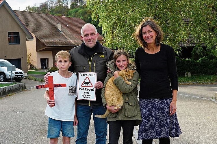 Hoffen auf viele Unterschriften: Familie Stöcklin fordert eine Temporeduktion – nicht nur in der Oberdorfstrasse. 
Das Kreuz in Noes Hand haben die Kinder für die toten Katzen gebastelt. Foto: Tobias Gfeller