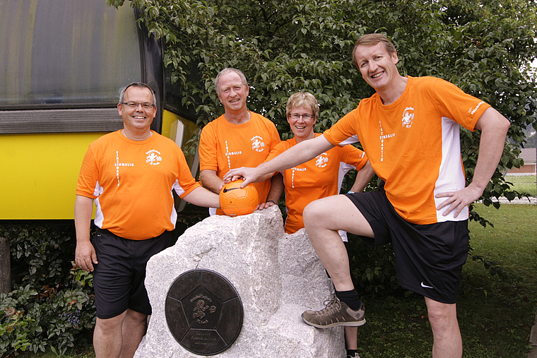 Ein Denkmal für die Aescher Fussballschule: Erich Mohn (Chef Trainer), Max Hunziker (Chef auf Platz), Heidi Gerster (Chef Verpflegung) und Christoph Heller (Chef Organisation) freuen sich über die in Stein gehauene Würdigung.  Foto: Lukas Hausendo