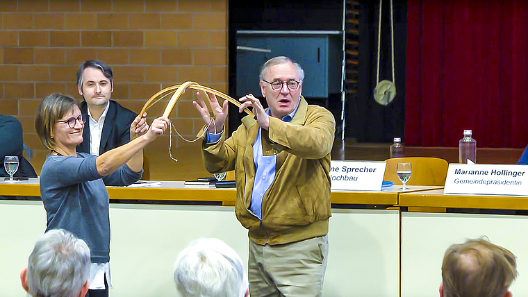 Anschaulich: Gemeinderätin Eveline Sprecher und Christoph Häring der Häring Holzbau AG hantieren mit der Dachkonstruktion des Holzdom-Modells.  Foto: ZVG/ Birsstadt TV / regioTVplus