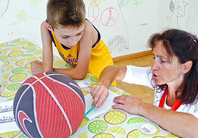 Zusammenarbeit: Der begeisterte Basketballer Denis zeichnet entsprechende Motive auf seinen Button; Treff-Leiterin Patrizia Bernardis gibt ihm dabei Tipps.  Foto: Thomas Immoos