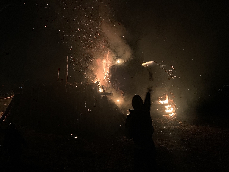 Anheizen: Ein Besucher wirft seine Fackel ins auflodernde Feuer. Foto: Caspar Reimer