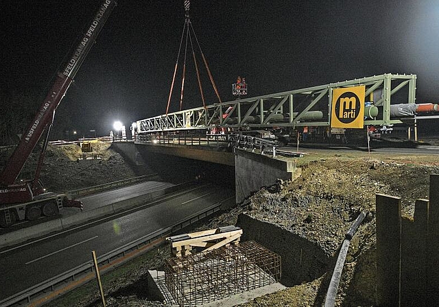 Drei Stunden Arbeit: Die Konstruktion stand auf dem Tieflader bereit und wurde vom Kran auf die Sockel versetzt. Die Rohrleitungsbrücke verläuft parallel zur Autobrücke über die A18 bei der Ausfahrt Reinach Nord. Foto: Juri Junkov