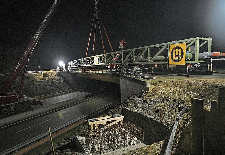 Drei Stunden Arbeit: Die Konstruktion stand auf dem Tieflader bereit und wurde vom Kran auf die Sockel versetzt. Die Rohrleitungsbrücke verläuft parallel zur Autobrücke über die A18 bei der Ausfahrt Reinach Nord. Foto: Juri Junkov