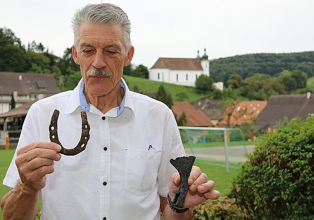 Nach harter Arbeit: Hubert Gehrig mit seinen zwei Lieblingsfunden aus dem Schlösschen, ein typisches Hufeisen und eine wunderbare Axt.