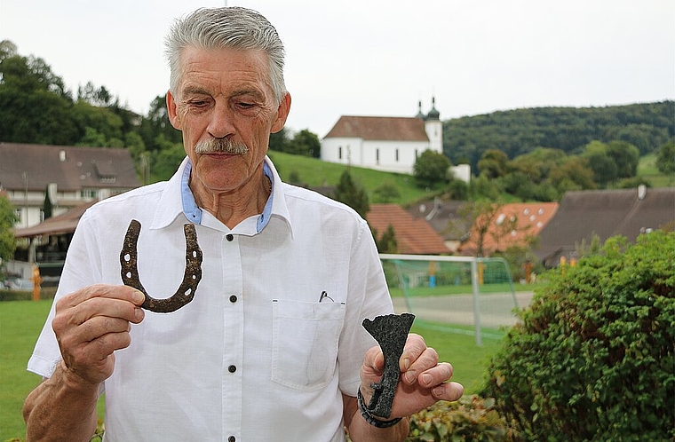 Nach harter Arbeit: Hubert Gehrig mit seinen zwei Lieblingsfunden aus dem Schlösschen, ein typisches Hufeisen und eine wunderbare Axt.