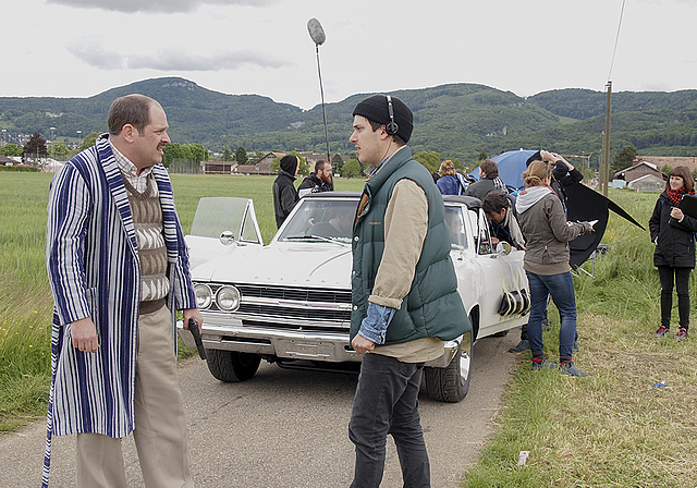 Vor der nächsten Einstellung: Regisseur Samuel Morris (r.) bespricht mit Schauspieler Nicolas Rosat, einer der Hauptdarsteller des Roadmovies «Doug & Walter», die nächste Szene. Im Hintergrund das weisse Fluchtauto. Foto: Tobias Gfeller