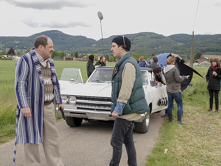 Vor der nächsten Einstellung: Regisseur Samuel Morris (r.) bespricht mit Schauspieler Nicolas Rosat, einer der Hauptdarsteller des Roadmovies «Doug & Walter», die nächste Szene. Im Hintergrund das weisse Fluchtauto. Foto: Tobias Gfeller