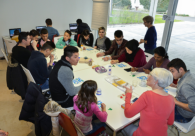 Willkommene Abwechslung im monotonen Flüchtlingsalltag: Im Pfarrhof St. Josef spielen Männer, Frauen und Kinder zusammen mit freiwilligen Helferinnen und Helfern einen Lottomatch.  Foto: Thomas Kramer