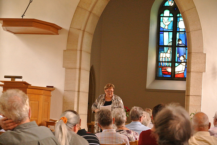 Aufmerksame Zuhörer: Meta Zweifel berichtet über die Geschichte und Geschichten rund um die Dorfkirche.  Foto: Bea Asper