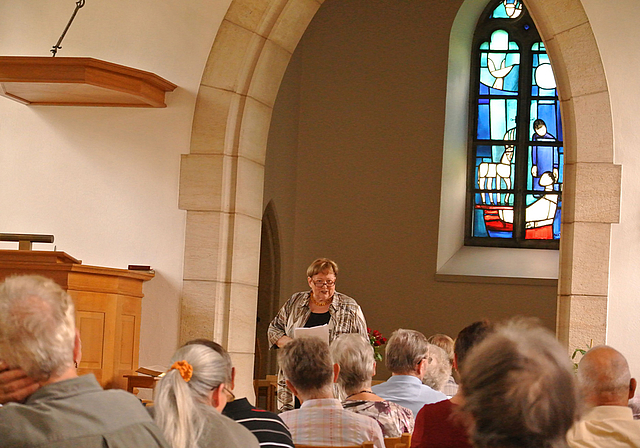 Aufmerksame Zuhörer: Meta Zweifel berichtet über die Geschichte und Geschichten rund um die Dorfkirche.  Foto: Bea Asper