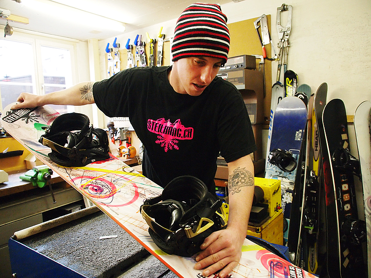 Mag Steilhänge: Lars Gross beim Präparieren eines Snowboards in seiner Werkstatt. Foto: Tobias Gfeller