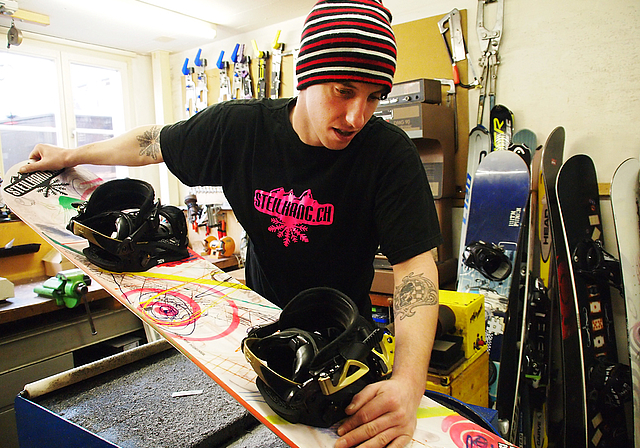 Mag Steilhänge: Lars Gross beim Präparieren eines Snowboards in seiner Werkstatt. Foto: Tobias Gfeller