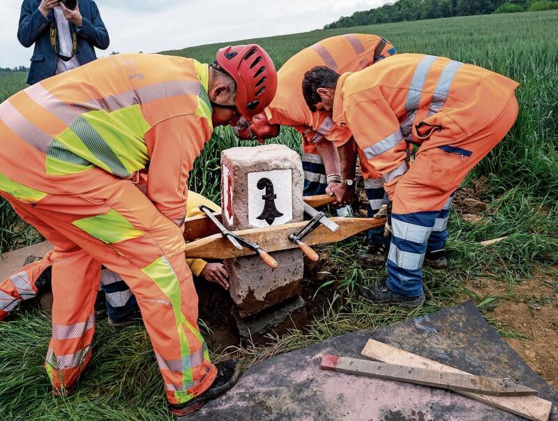 Millimetergenaue Handarbeit: Der besondere Grenzstein Nummer 85 wird platziert. Fotos: Kenneth Nars
