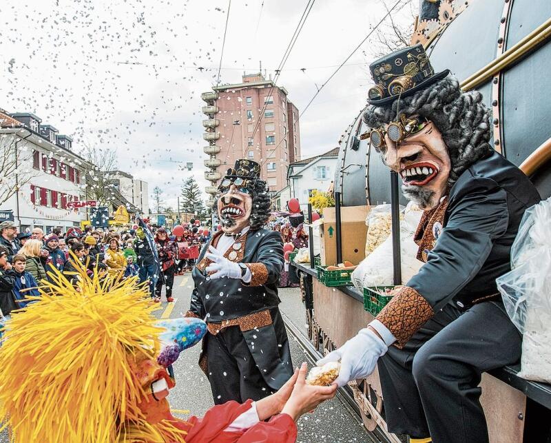 Gemüse für die Zuschauer: Die Nochwuchs Waggis Birsegg dampften mit einer riesigen Lokomotive durch Reinach. Foto: Nicole Nars-Zimmer
