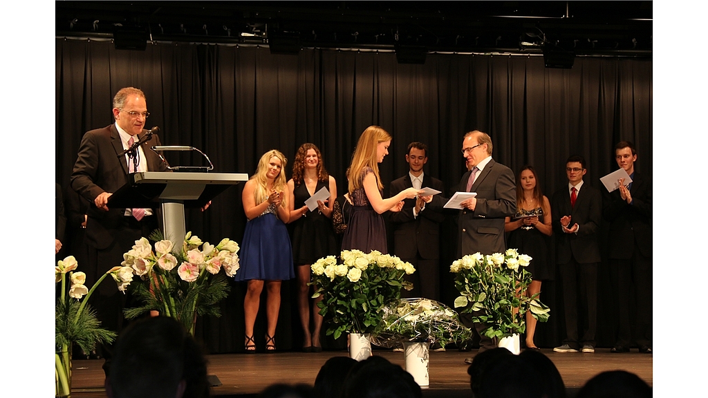 Maturafeier: Rektor Isidor Huber ruft die Maturandinnen und Maturanden auf; auf dem Foto überreicht gerade Klassenlehrer Peter Hellinger Maja Wolleb, die ebenfalls den Ricola-Preis erhielt, das Zeugnis. Fotos: Gaby Walther
